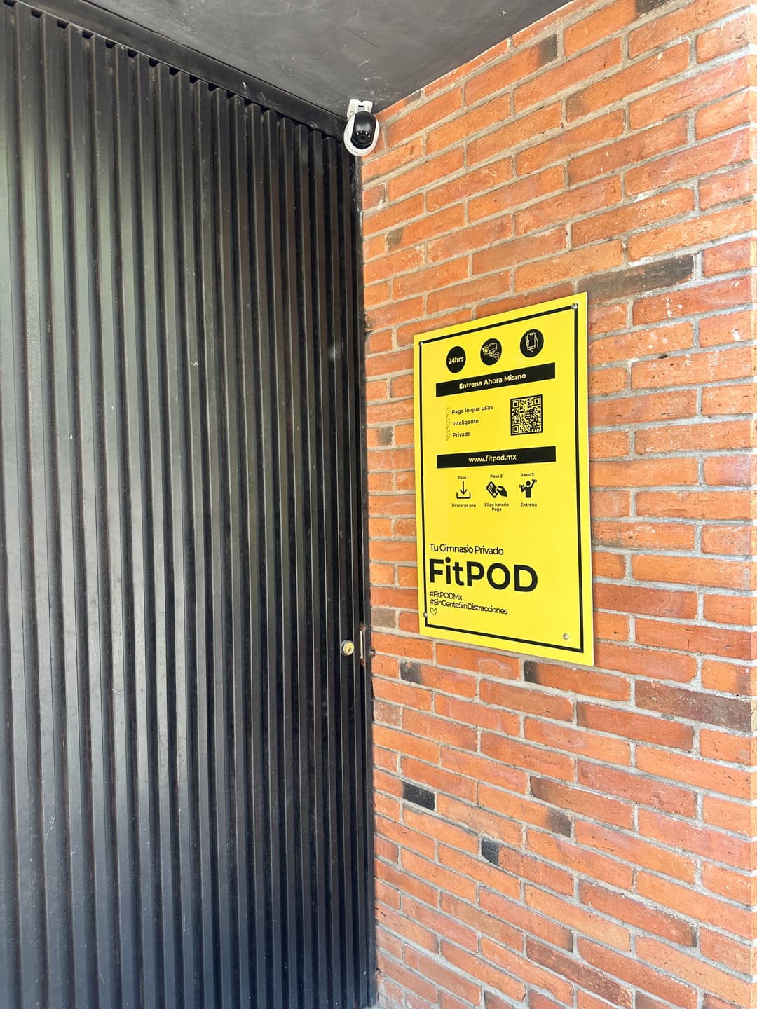 Black door and yellow FitPOD sign at the entrance